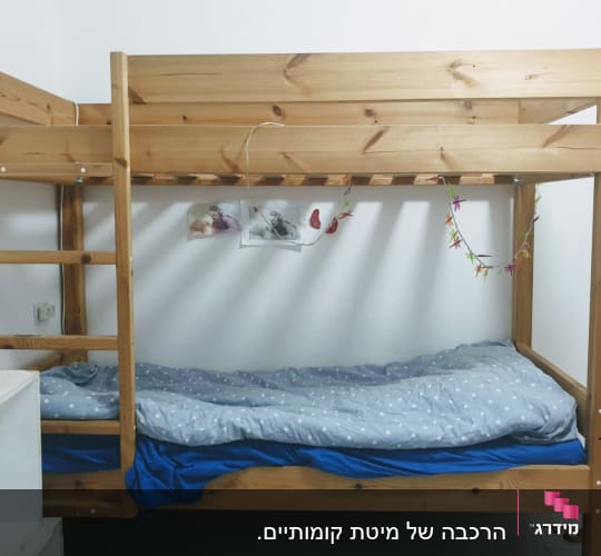מיטת קומותיים מעץ עם סולם בצד